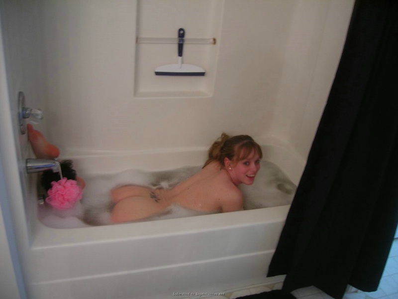 Молодая красотка, лежа на кровати, демонстрирует своё тело порно фото